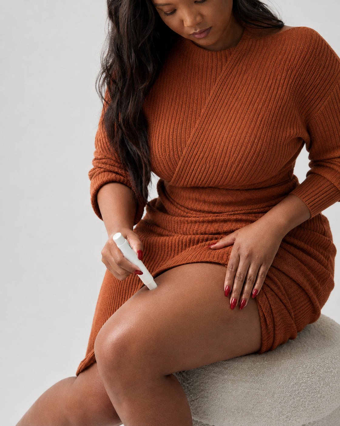 Woman self-administering a medication injection into her thigh